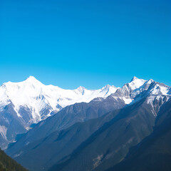 Obraz premium Snow-covered mountains under a bright blue sky in a remote wilderness