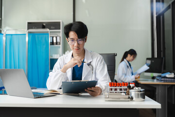 Medical Technology Concepts. Medical students use mobile phones and laptop to search for information in a modern office in the morning at the desk.