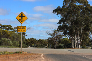 Railway not in use, sign. Decline in use of rail network and built infrastructure in rural, Outback Australia. Gum eucalyptus trees, copy space.