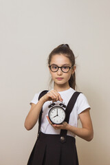 girl schoolgirl with an alarm clock her hands