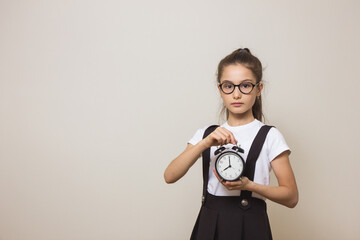 girl schoolgirl with an alarm clock her hands