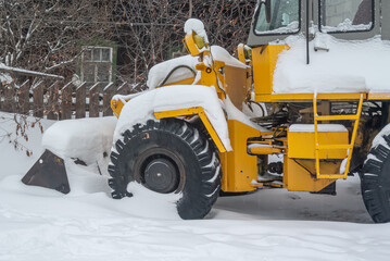 A bulldozer for clearing roads of snow during a snowfall. Street and road cleaning equipment in winter. Road equipment.