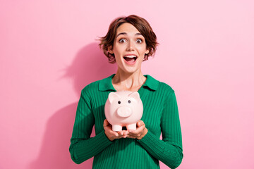 Photo of overjoyed impressed girl with bob hairdo dressed green shirt hold money piggy box in hands...