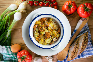 Healthy potato, onion and sausage salad. Top view table with decorations.