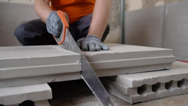 Construction worker assembling lightweight concrete blocks using a level