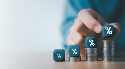 Businessman putting percentage sign on increasing coins money for financial banking increase...