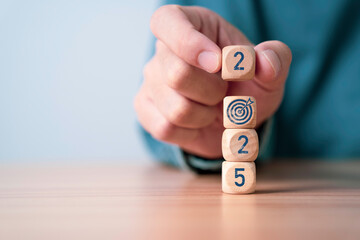 Businessman putting 2025 and target board arrow for focus and preparation business objective target...