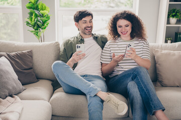 Obraz premium Photo of two young people sit couch show smart phone modern interior apartment indoors