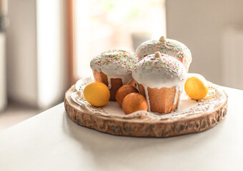 Three Easter cakes and yellow painted eggs on the table.