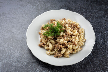 A plate of pasta with meat and vegetables on top