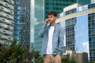 A guy talking on a mobile phone against the backdrop of the Moscow City towers
