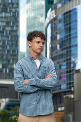 A young man stands at the Moscow City towers and looks into the distance