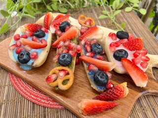 Yogurt top of banana with strawberry mixed blueberries and pretzels