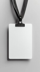 Blank white ID card with black lanyard on gray background.