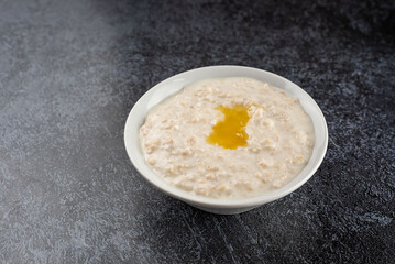 A bowl of oatmeal with a small amount of oil on top