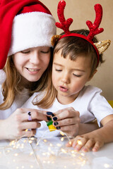 Portrait of children on New Year's Eve at home doing crafts at table Merry Christmas. Happy New Year