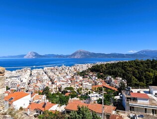 Panoramic view of trees, a bay and the houses of the city of Patras in Greece on the Peloponnese peninsula. Sightseeing and vacation in Greece. 