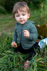 A boy on the shore in the green grass has a picnic