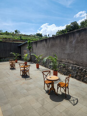 The wood tables of the coffee shop are outdoor with views of the green farmland and the blue sky. 