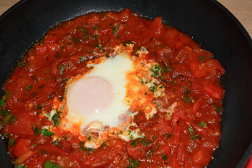 Ready-made shakshuka dish of traditional oriental cuisine close-up. Top view. Cooking at home
