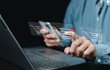 Shopping online and e-commerce technology concept. A person using smartphone and laptop, with several digital shopping cart icons displayed, represents online shopping and e-commerce. shop on internet