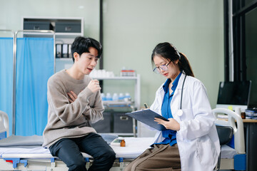 Obraz premium Asian male patient on bed while doctor hands of checking examining his pulse for record the treatment results