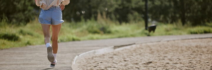 Website banner of unrecognizable athletic woman running away in park