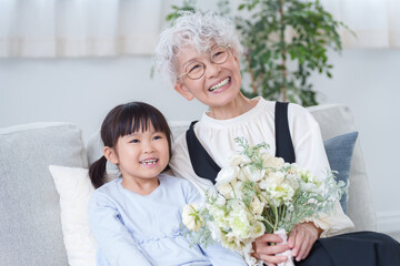 花束のプレゼントを持つおばあちゃんと孫