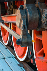 A close-up of the red wheels of the retro Steam locomotive.