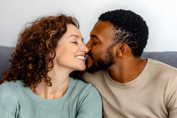 Obraz premium A African man and Caucasian woman share a warm, affectionate kiss at home, reflecting their deep bond.
