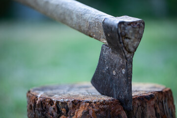 The axe stuck on wooden log