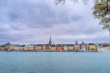 A picturesque panoramic view of Stockholm, Sweden. The iconic Skeppsholmsbron bridge, with its golden crown, stands out against the city skyline.