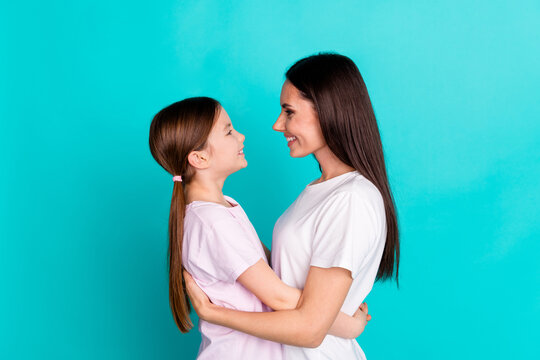 Photo of pretty cute nice lovely girl and mom hugging dressed white stylish clothes isolated on cyan color background