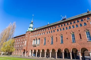 Fototapeta premium Stunning view of Stockholm City Hall, known for its iconic red brick facade and towering spire. The complex structure and grandeur of the building make it a symbol of Sweden. Stockholm, Sweden.