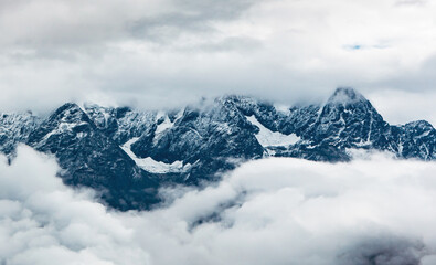 Obraz premium Snowy Mountains in the Clouds and Mists of the Eastern Qinghai Tibet Plateau
