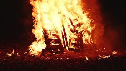 Bonfire pyre burning at night, bright orange flames of fire, 4K