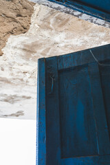 The open, blue doors of the main entrance, to an abandoned, rustic store