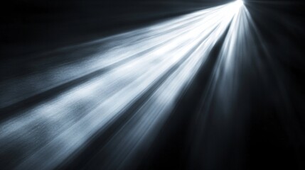 A diagonal beam of light illuminates a dark, textured surface.