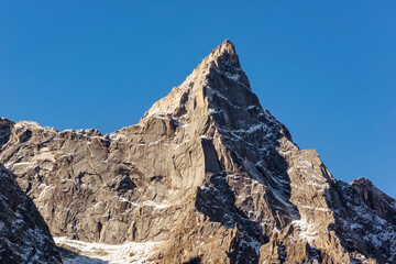 Steep snow-capped mountains under clear blue skies - Powered by Adobe