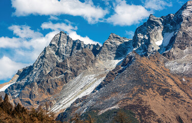 Snowy mountains under blue and cloudy sky