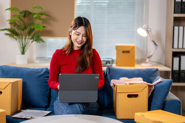 A woman is sitting on a couch and using a laptop