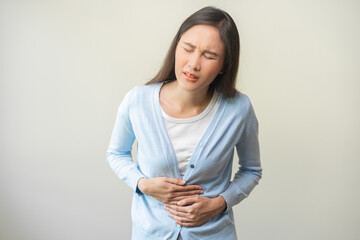 Obraz premium Flatulence ulcer, asian young woman, girl hands in belly, stomach pain from food poisoning, abdominal pain and digestive problem, gastritis or diarrhea. Abdomen inflammation, menstrual period people.