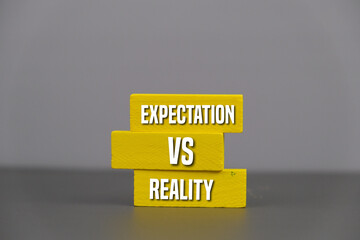 text of EXPECTATION VS REALITY. a comparison concept written on yellow wooden block. 