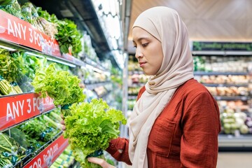 Happy mature Asian woman looking  products at grocery store. Costumer buying food at the market. Woman enjoying her time shopping at the grocery store