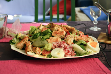 Prepared Caesar salad on a plate on the table close-up. Menu of restaurants and cafes. Side view