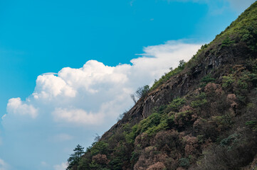 Mountain slopes and blue sky with white clouds