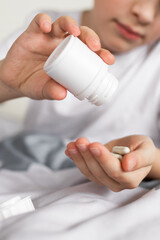 Child eating pills and  supplement vitamins for better immunity. Child taking medicines pills.Medical concept.