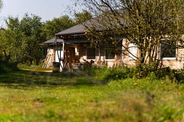 Dom w budowie na wsi otoczony zielenią w słoneczny dzień