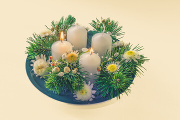 advent wreath with four white candles, 2 candles burning