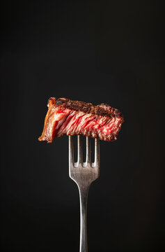 Juicy grilled steak slice served on a fork, delicious cooked meat for a tasty gourmet dining experience